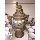 A late 19th century brass urn with Sevres style painted porcelain central part