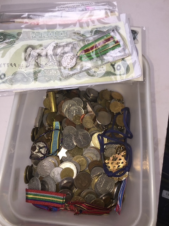 A box of world bank notes, coins and medals