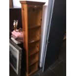 A tall narrow pine bookcase