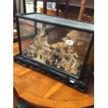 An eastern carved diorama in glass display box