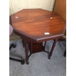 An Edwardian octagonal table with turned legs and castors