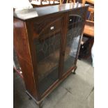 An oak leaded glass bookcase on cabriole legs