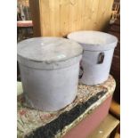 A pair of hard round hat boxes