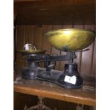 A set of metal weighing scales with brass trays and weights