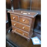 A pine miniature chest of drawers