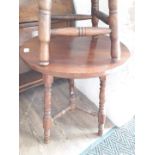 A late Victorian round occasional table with turned legs and cross stretcher.