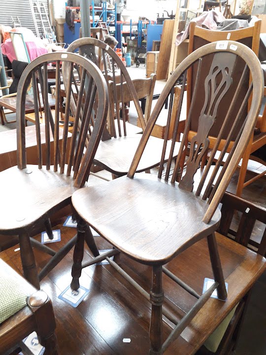 Three elm and ash seated spindle back chairs, and a ladder back chair.