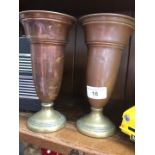 A pair of copper and brass ecclesiastical cups with engraved cross on them.