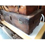 A large vintage brown leather travel trunk.