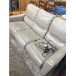 A grey leather electric reclining three seater settee.