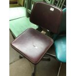 A retro burgundy office swivel chair.