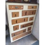 A mixed wood and cream painted chest of drawers.