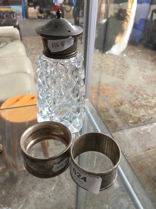 A silver topped shaker / sifter and 2 silver napkin rings.