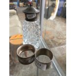 A silver topped shaker / sifter and 2 silver napkin rings.