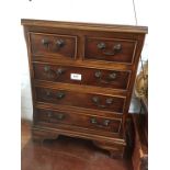 A small five drawer reproduction chest of drawers.