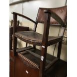 A 1930s leather and oak armchair.