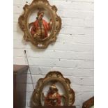 A pair of moulded plaster decorations depicting a man and woman.