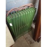 A vintage small green painted cast metal electric radiator (display only).