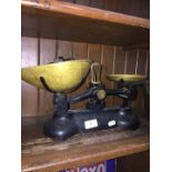 A vintage cast metal set of scales with brass plates and weights.