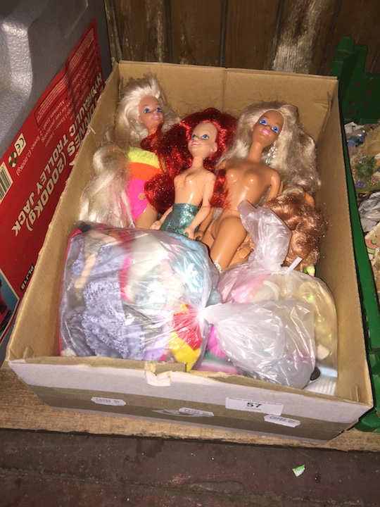 A box of various Barbie dolls