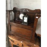 An oak hall bench with stick stand arms