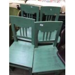 A set of four green painted chairs.