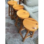 Four pine kitchen stools.
