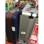 2 suitcases - 1 metal and 1 leather.