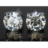 A pair of diamond stud earrings, the four claw set modern round brilliant cut diamonds weighing