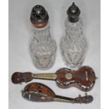 A pair of glass bottles with turned wood tops and a two tortoiseshell guitars.