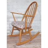 An Ercol blonde elm and beech Windsor rocking chair with spindle back and floral upholstered seat,