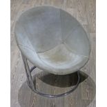 A retro suede bucket chair hung on chrome frame.