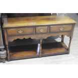 An aged oak Georgian style dresser of small proportions with three drawers, shaped frieze, turned