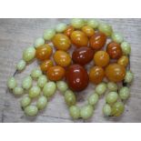 16 loose pressed butterscotch amber beads wt. 40g, together with a stand of glass beads.