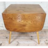 An Ercol blonde elm and beech kitchen drop leaf table, min. length 64cm, depth 74cm & height 72cm.