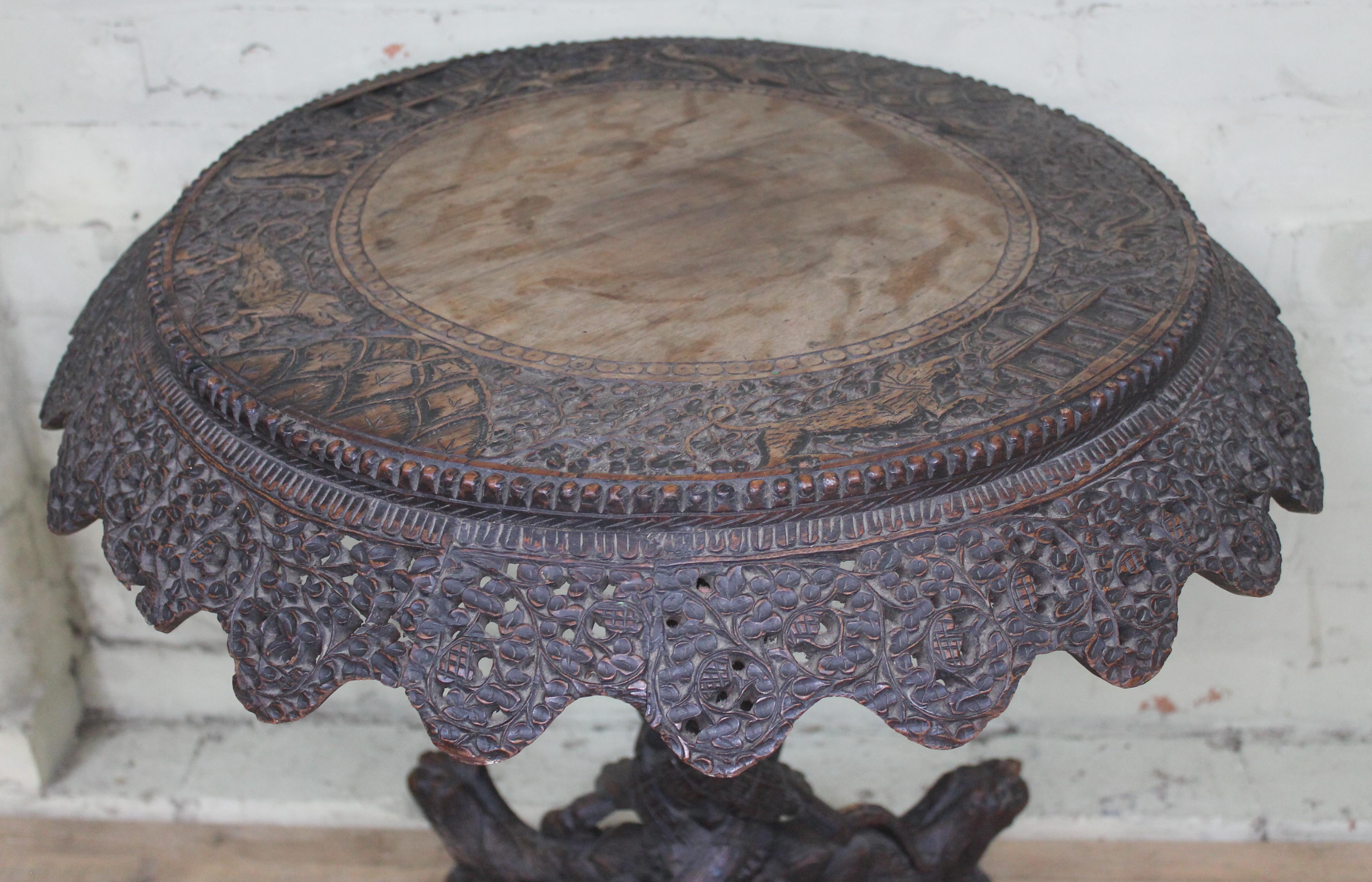 A 19th century Anglo-Indian rosewood tripod table with flip top and carved profusely with hunting - Image 6 of 6