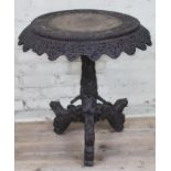 A 19th century Anglo-Indian rosewood tripod table with flip top and carved profusely with hunting
