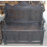 A late 17th century and later carved oak settle, width 115cm, depth 50cm & height 108cm. Condition -