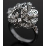 A diamond cluster cocktail ring featuring two flower heads above open scroll work, crafted in