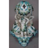 A 19th century Minton style centrepiece formed as three cherubs holding aloft a sphere, interspersed