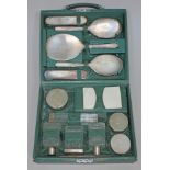 A Mappin & Webb green leather bound vanity case, the interior fitted with a sixteen piece silver and