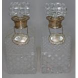 A pair of hallmarked silver mounted cut glass decanters, each with a hallmarked silver label, one