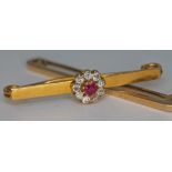A 9ct gold brooch set with a flower head cluster of old cut diamonds and a pink sapphire, cluster