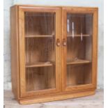 A elm and beech glazed bookcase with internal adjustable shelves and visible dovetail joints,