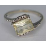 A 10ct white gold ring set with a pale yellow mixed cut stone, marked '10k', gross wt. 1.81g, size