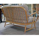 An Ercol blonde elm and beech Windsor settee with floral upholstery, width 132cm, depth 76cm &