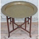 A Chinese brass top table with folding hardwood base circa 1900, diam. 66cm & height 54cm.