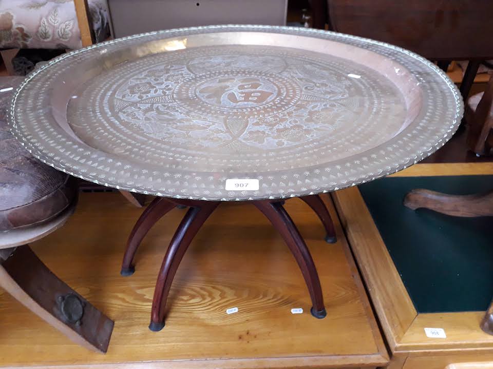 An eastern brass charger with folding table base