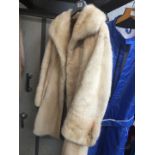 A fur coat, honey colour, with sides pockets, buttoned up, approx size 8 - 10.