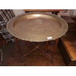 A Chinese brass top table with folding hardwood base circa 1900, diam. 66cm & height 54cm.